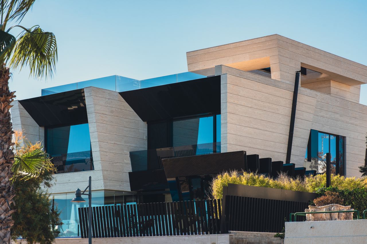 why-choose-us Contemporary architecture with sleek design featuring palm trees and blue sky.