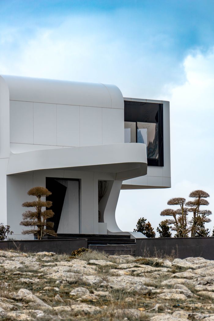 gallery-6 A sleek white modern building with futuristic architecture set against a cloudy sky, located in Ankara, Türkiye.