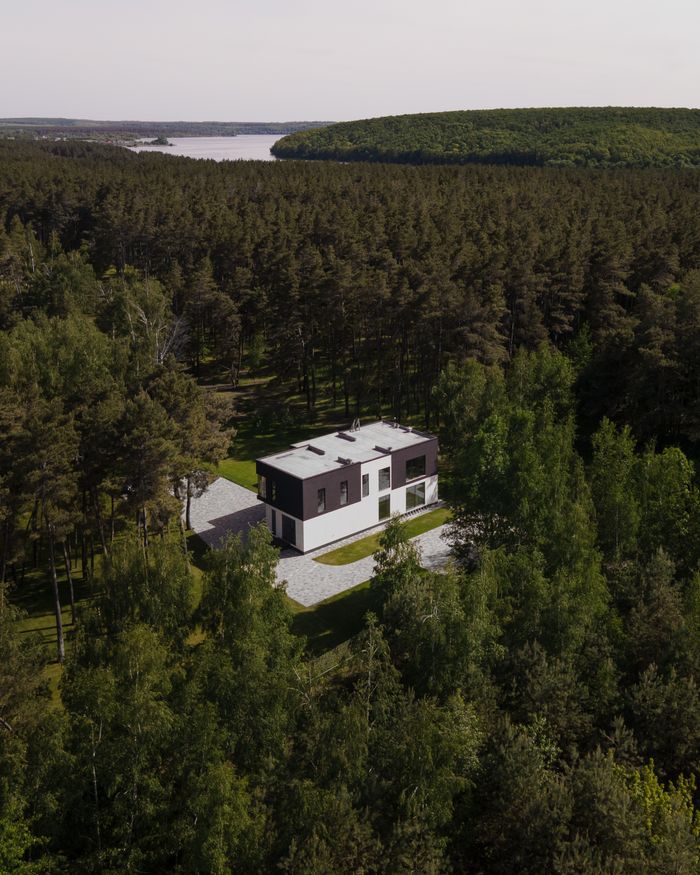 services-02 Aerial view of a modern house nestled within a dense forest in Solomino, Russia.